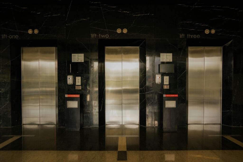 product hero Sleek elevator lobby with stainless steel doors, reflecting modern architecture.